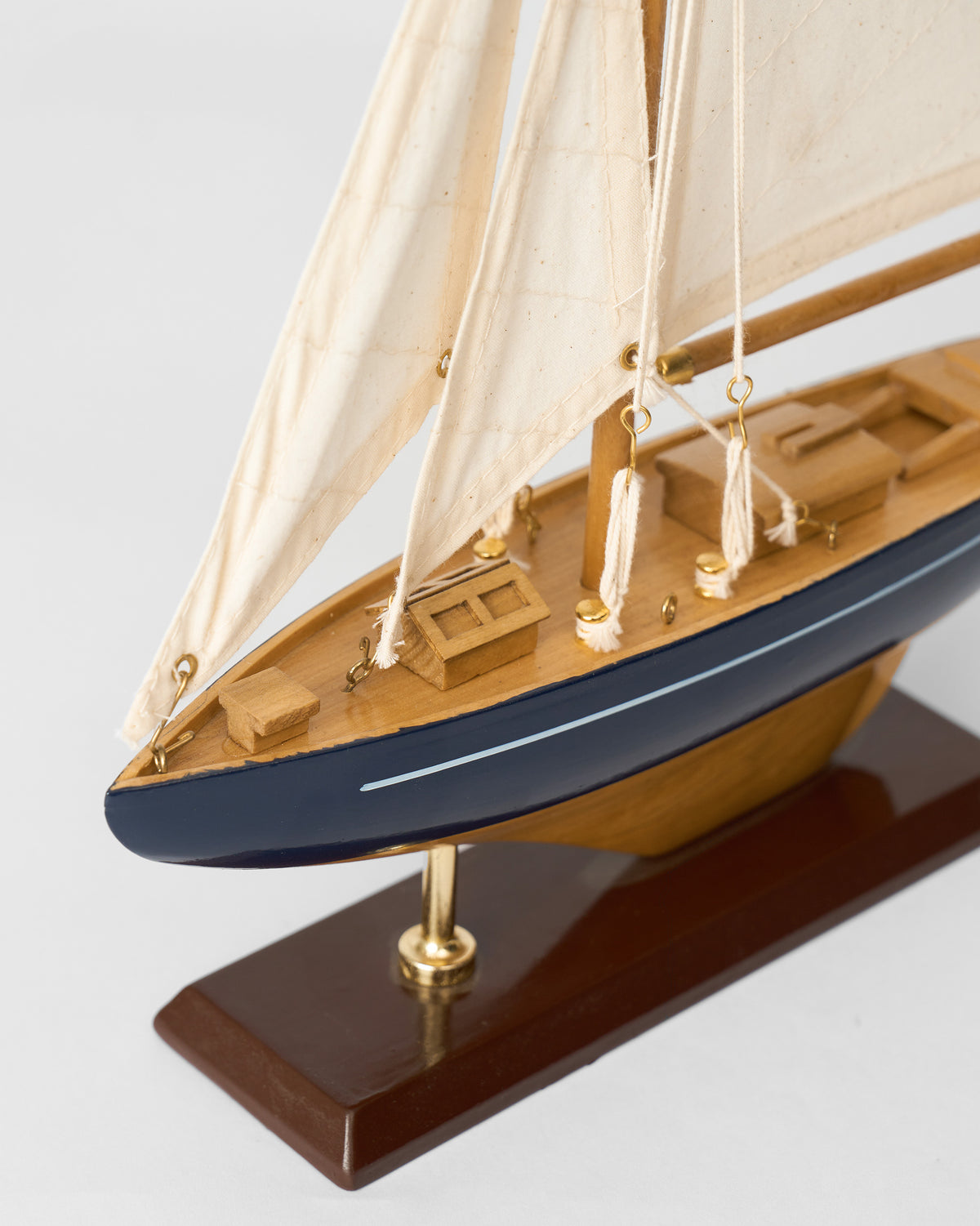 Close-up of the Sail Boat Home Accent bow and deck on a brown base.