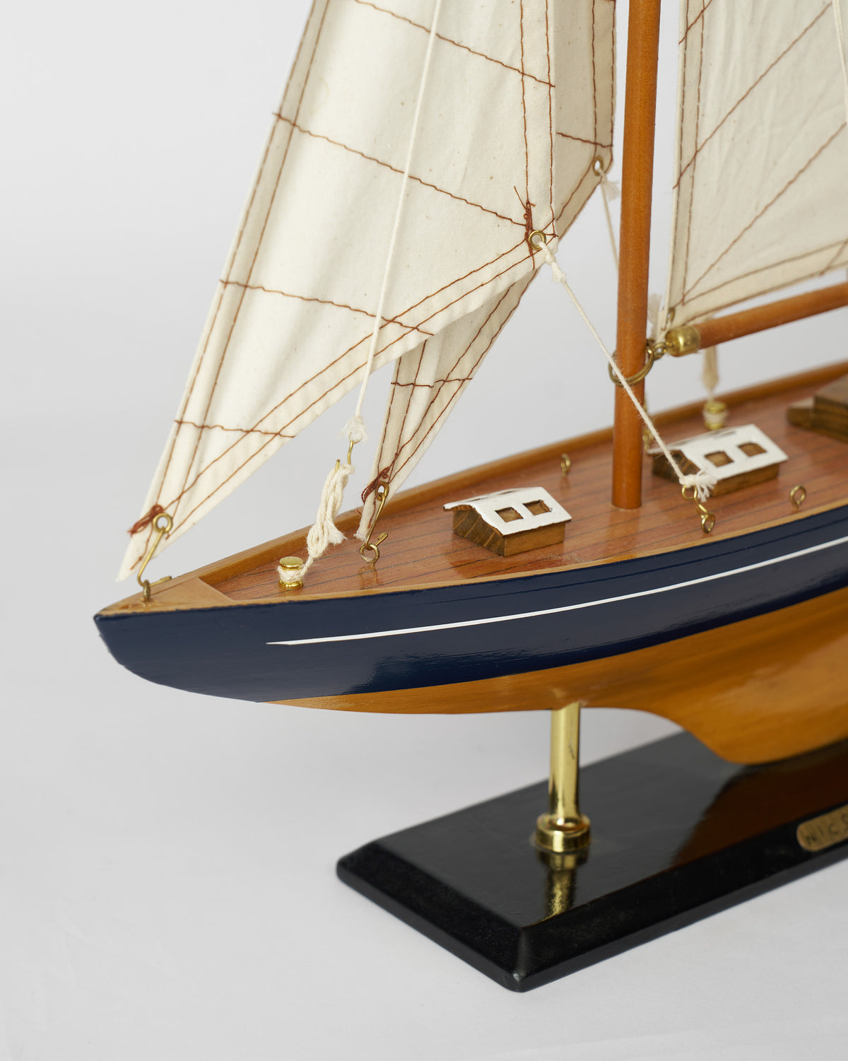 Close-up of the Sail Boat Home Accent bow and navy hull.