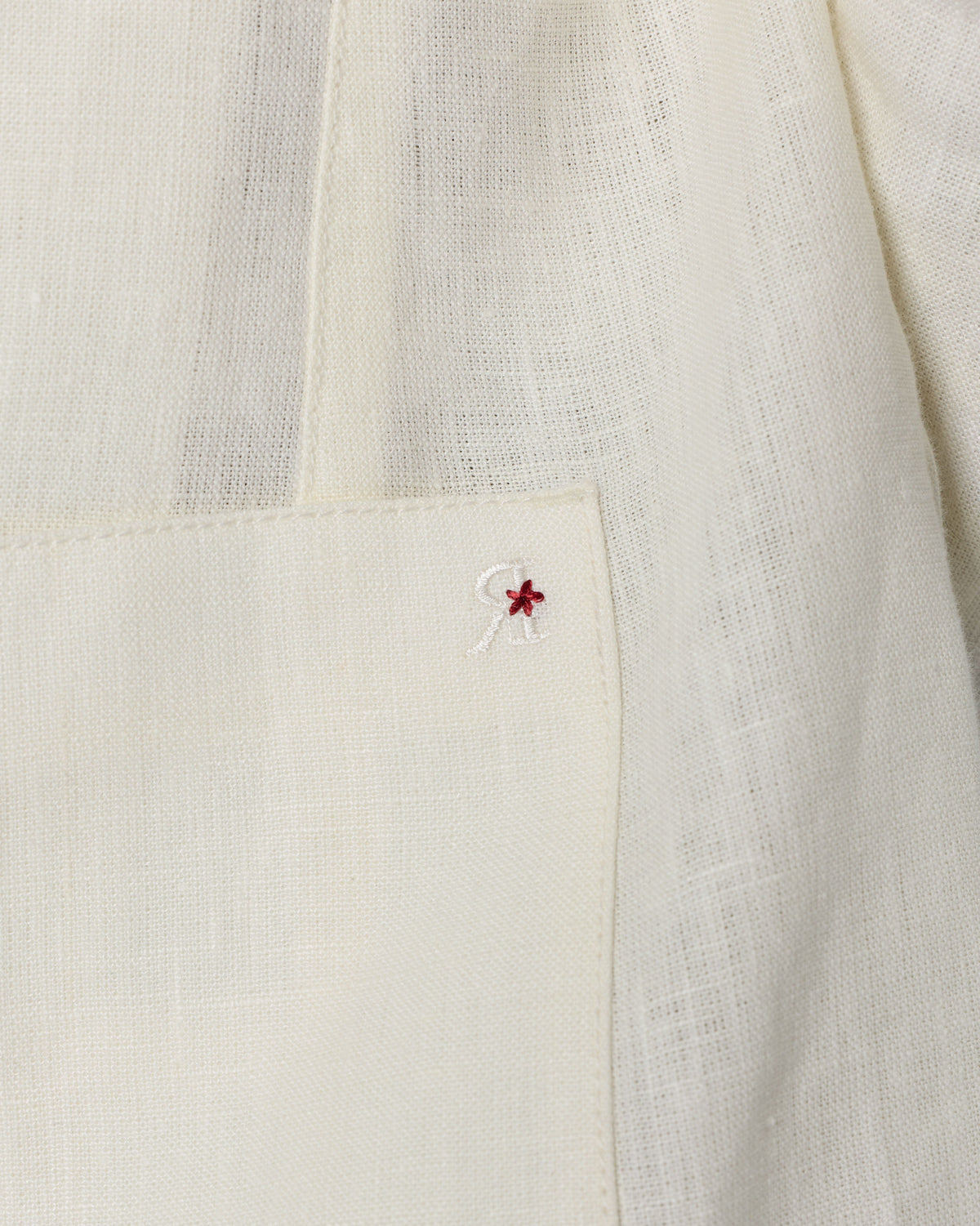 Close-up of the Tahr Bandhgala chest pocket with a small red embroidered motif.
