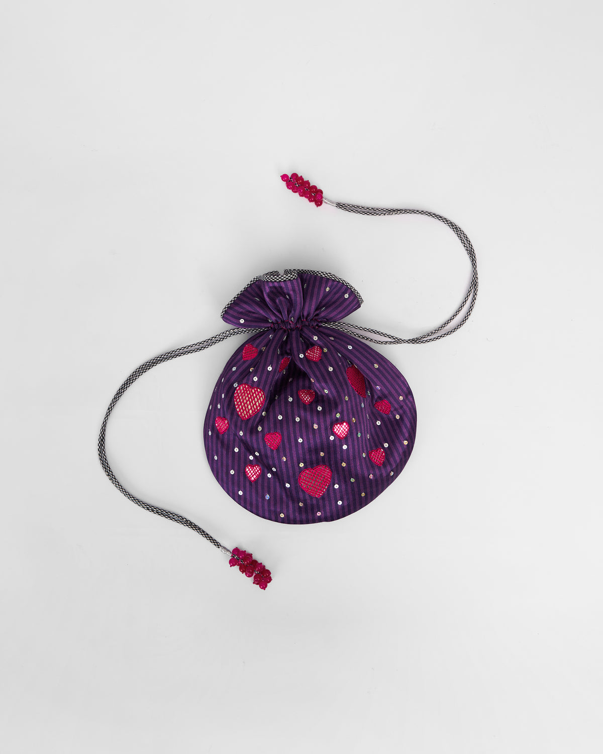 Violet Meher Potli laid flat with pink heart motifs and drawstring tassels.