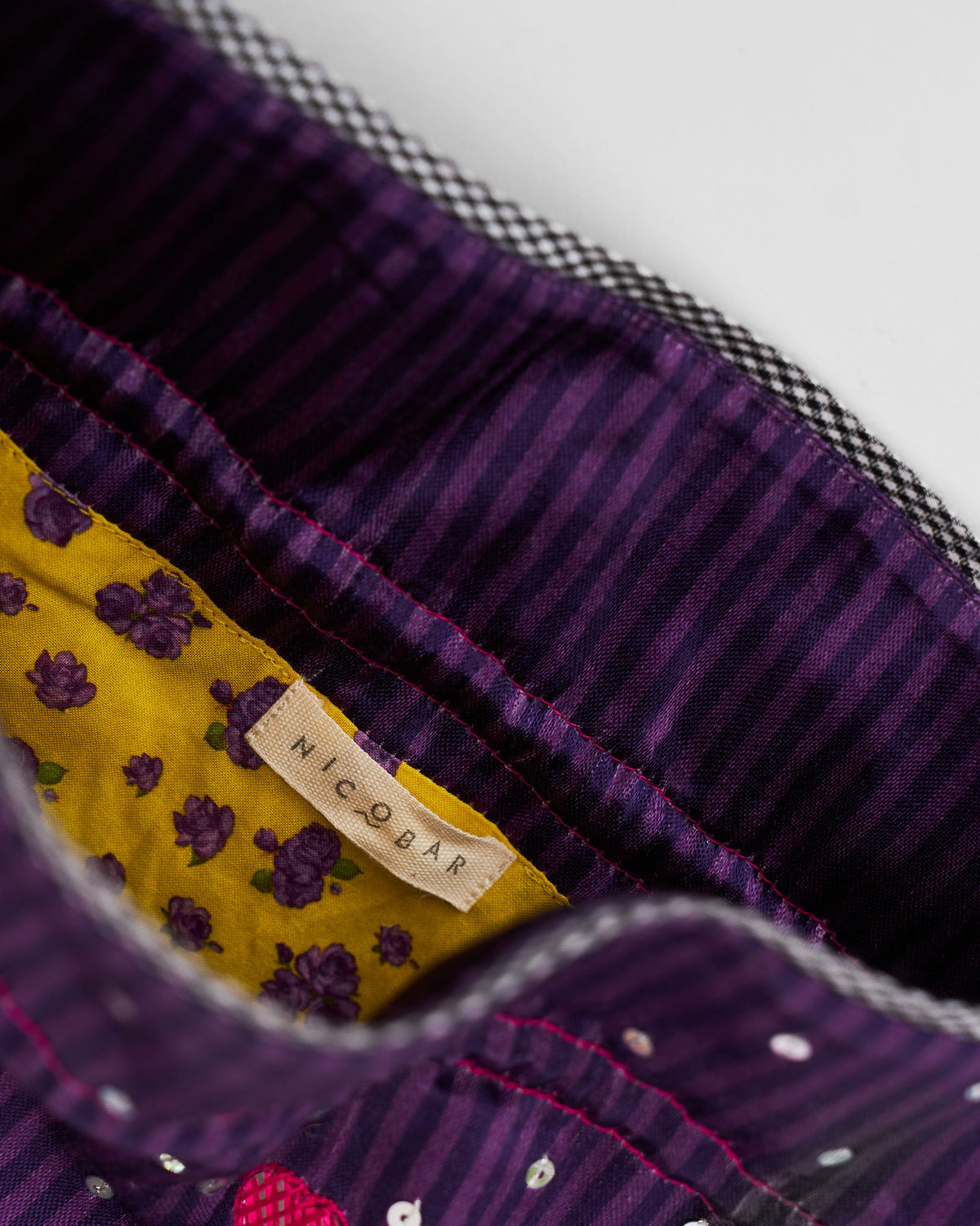Close-up of the Meher Potli interior with a mustard floral lining and Nicobar label.