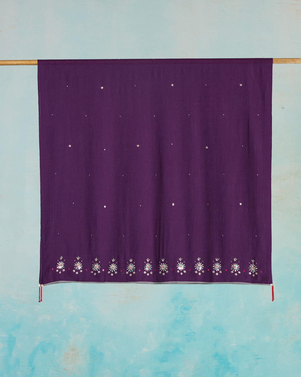 Violet Bahaar shawl hung flat, with embroidered flowers along the lower edge.