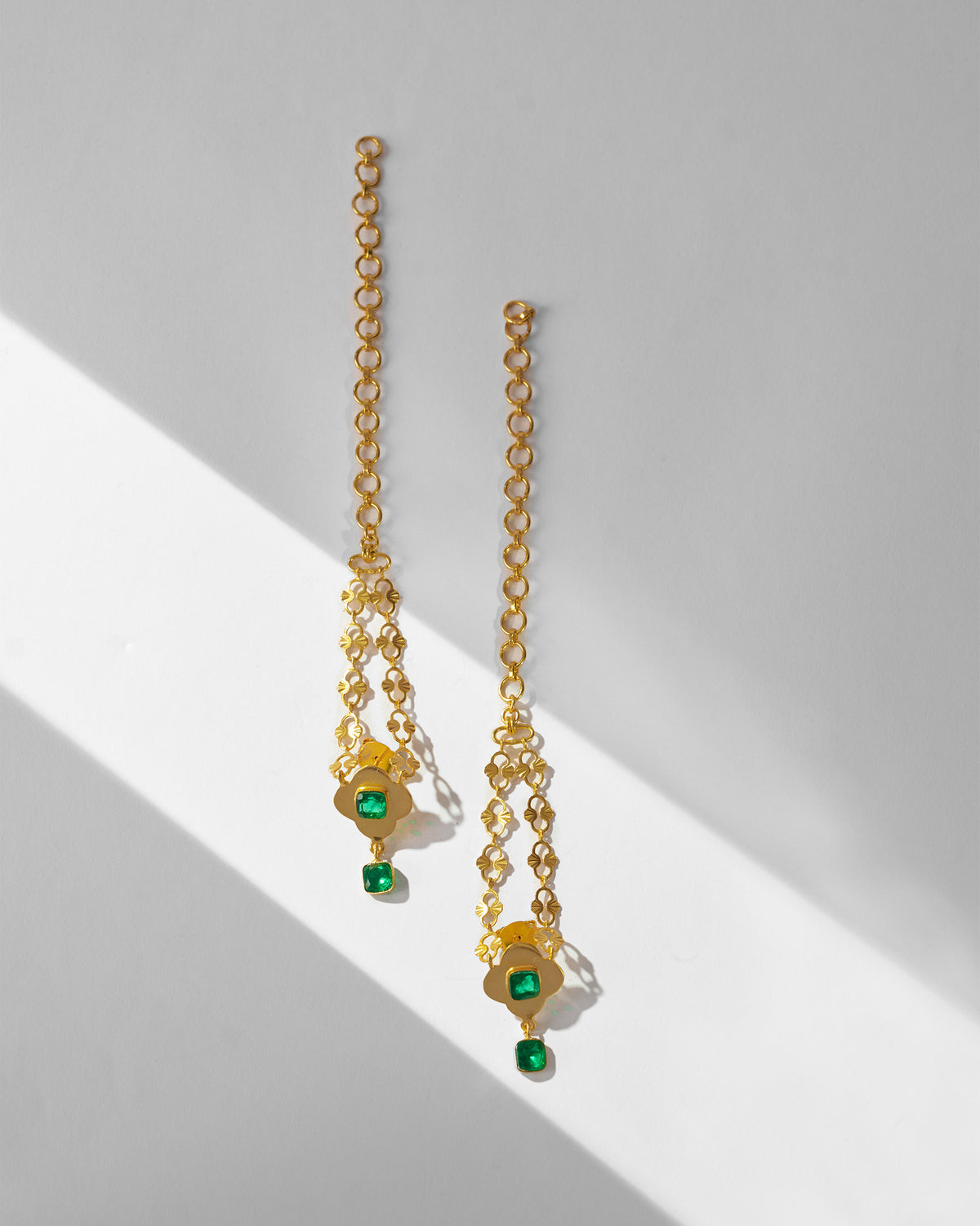 Pair of gold Clover Kanauti earrings laid flat.