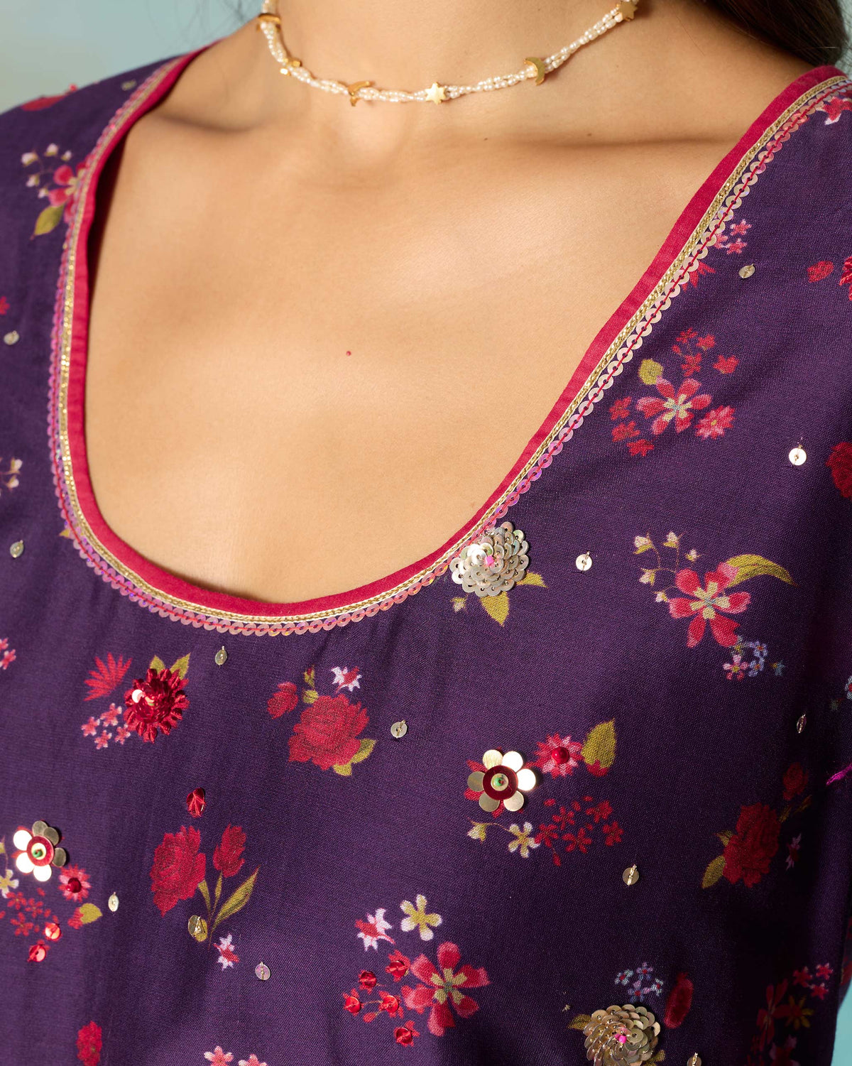Close-up of the Sehra kurti neckline with pink piping and gold lace trim.