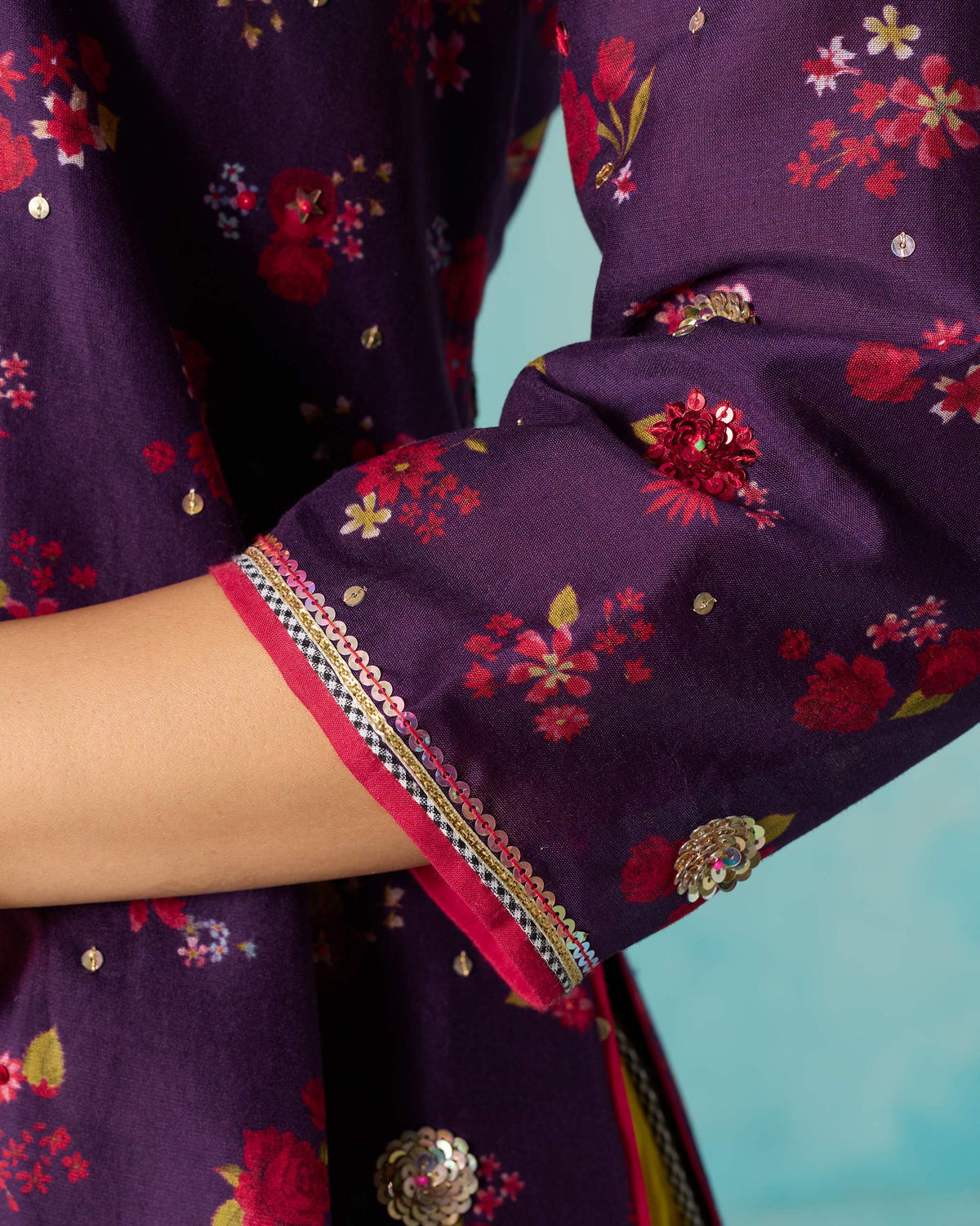 Close-up of a Sehra kurti sleeve with pink piping and gold trim at the cuff.
