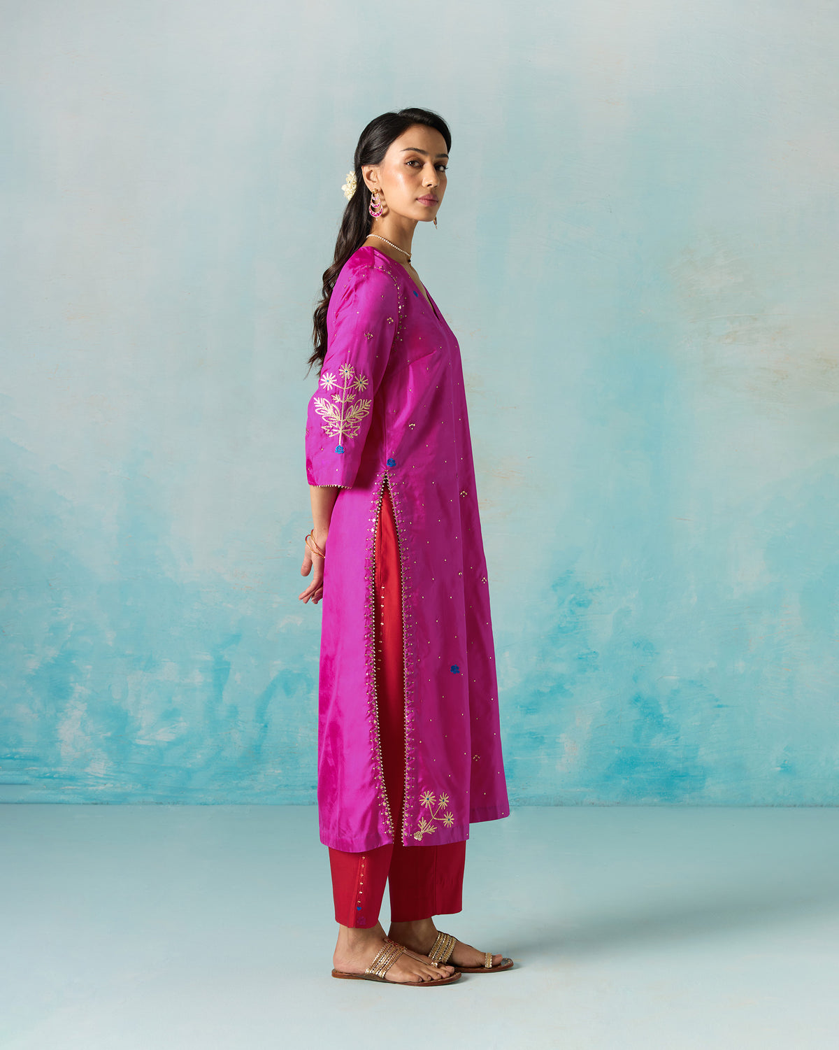 Side view of a magenta Milni kurta with embroidered sleeves.