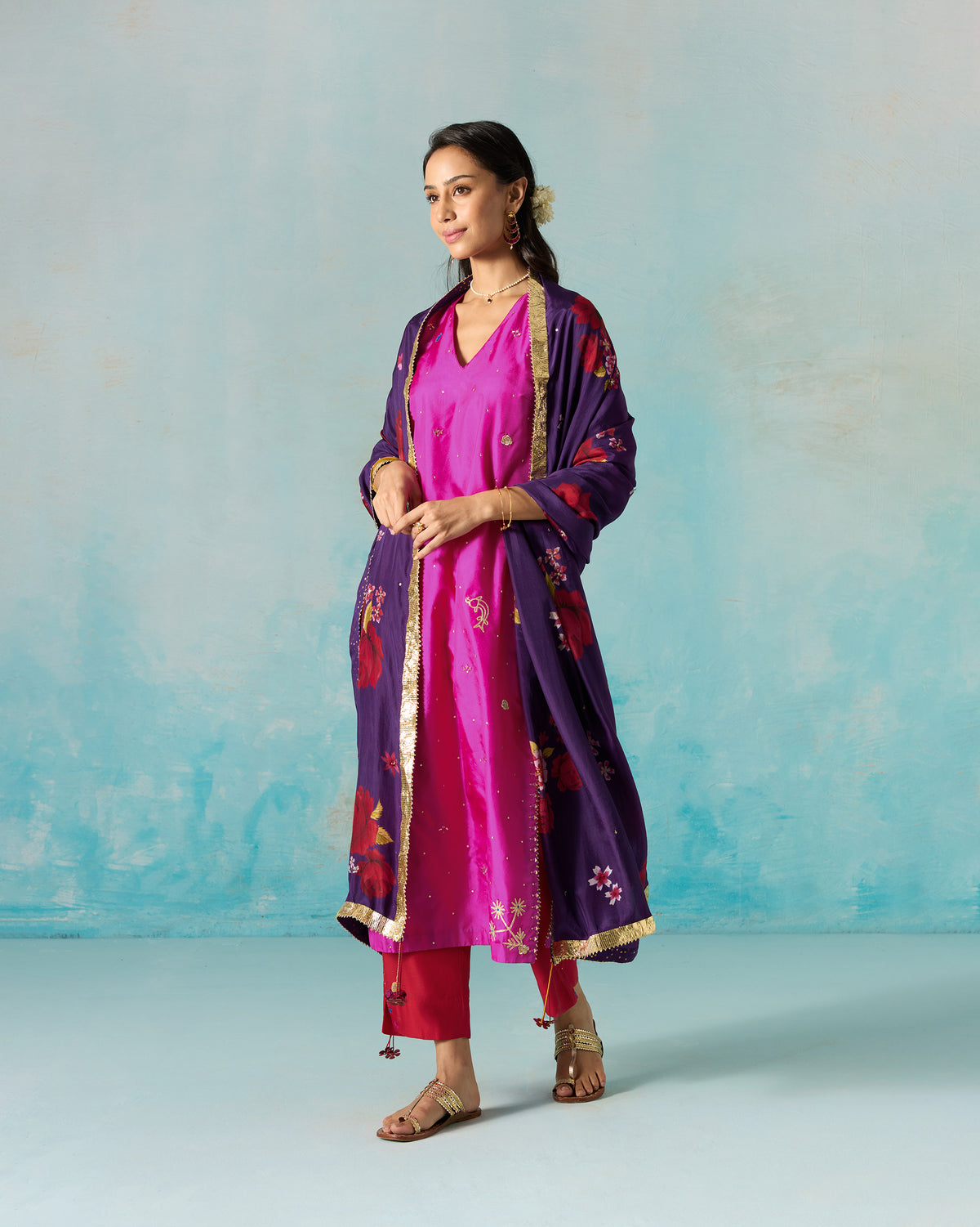 Person wearing a magenta Milni kurta, styled with a purple dupatta.