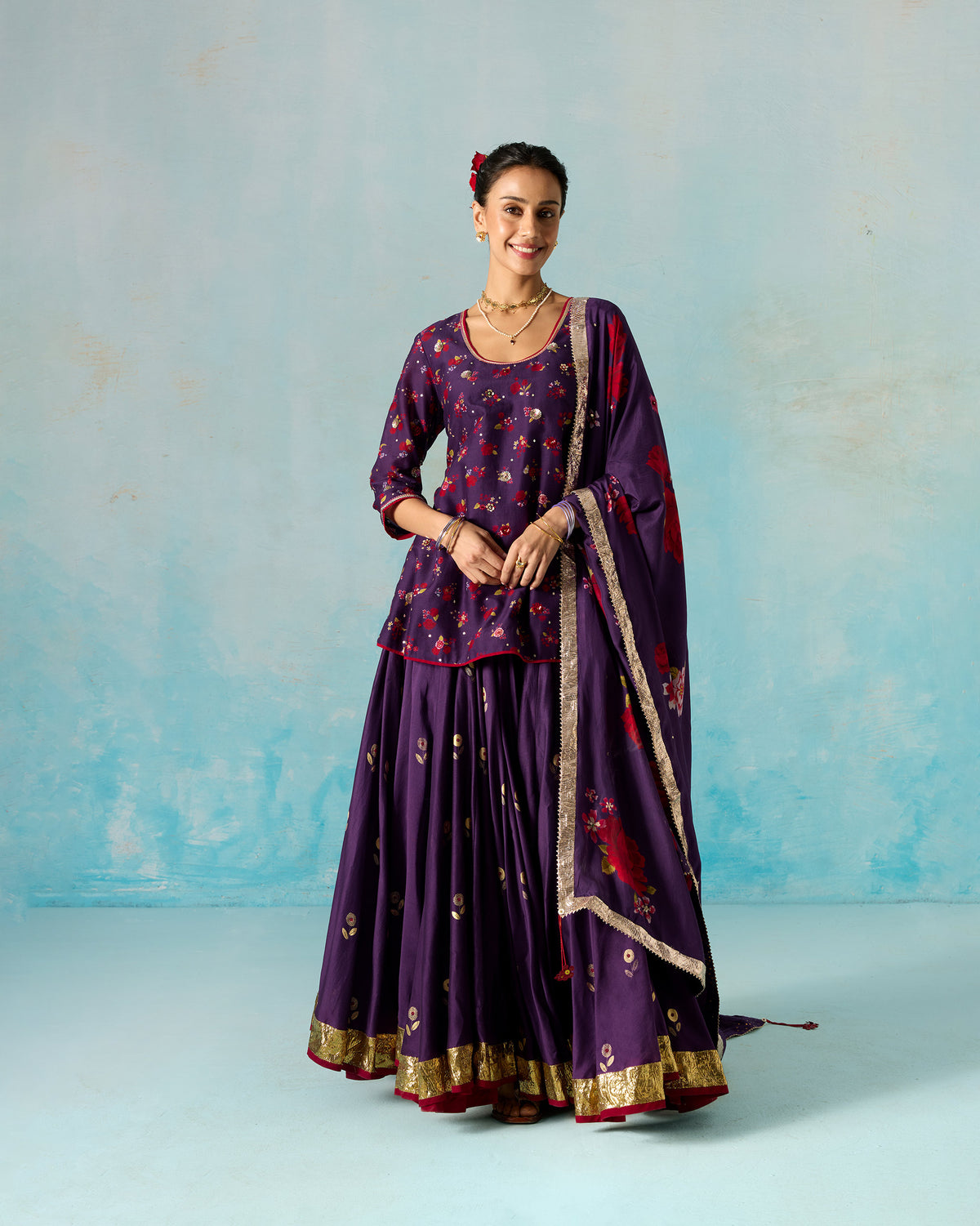 Person wearing a yellow Berura skirt with a purple floral top and dupatta.