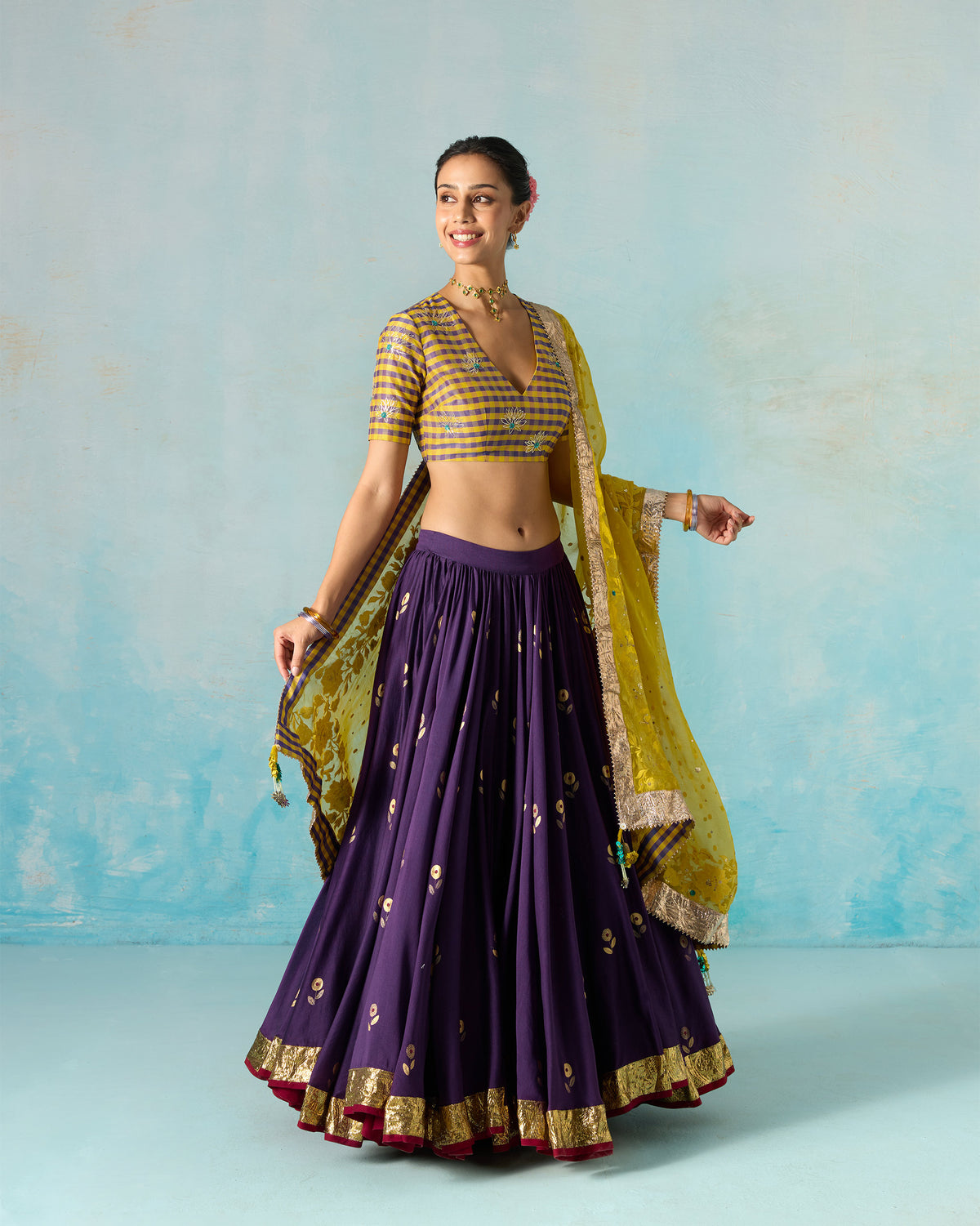 Person wearing a purple Saaya skirt with gold foil motifs.