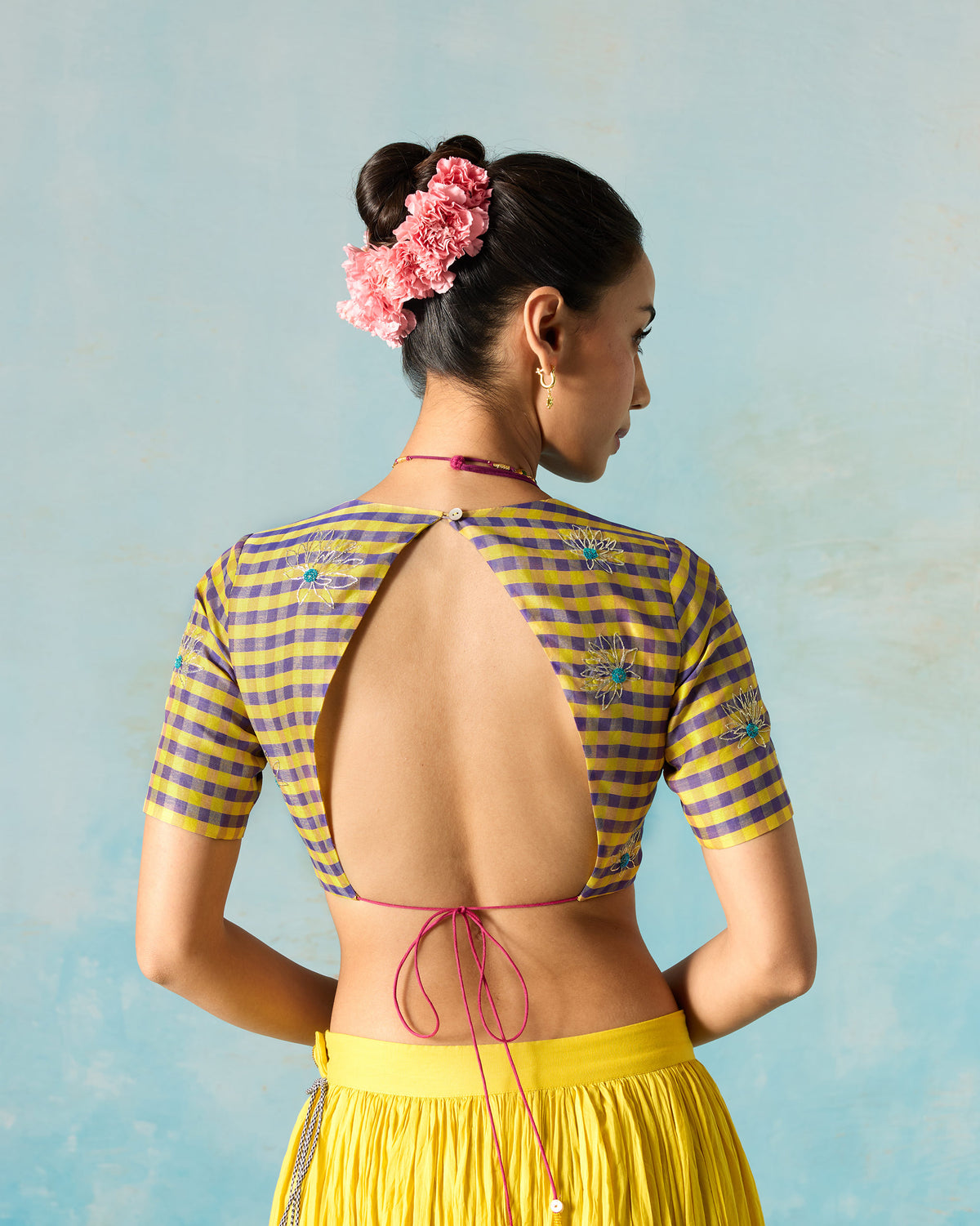 Back of a Dori blouse worn by a person, showing the open back and tie strings.