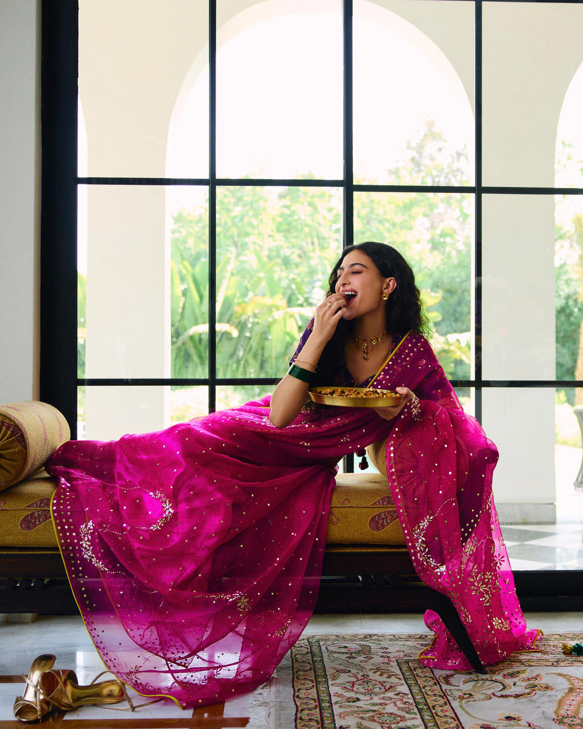 Person draped in a magenta Milan sari with embroidery and a gold border.