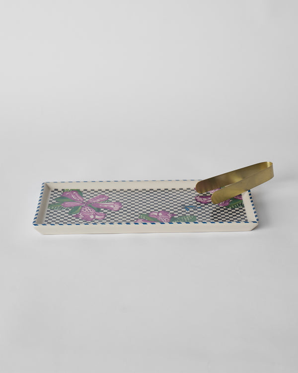 The tray side-on with the tong resting in it
