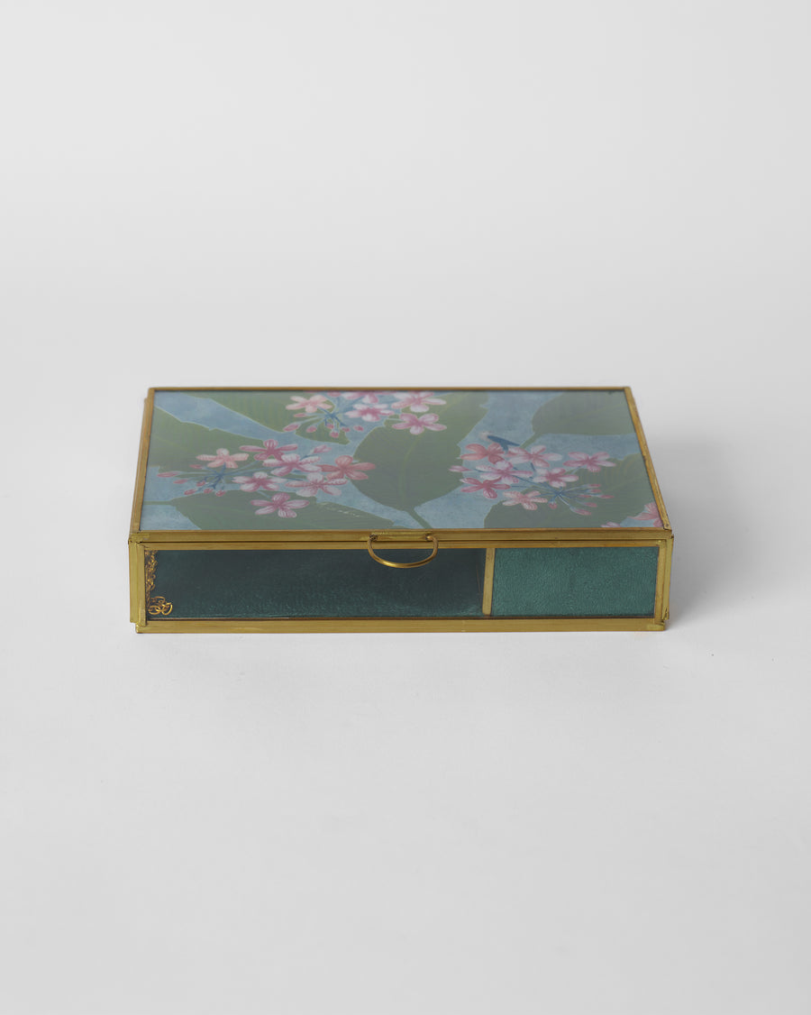 The closed box, its painted lid in a brass frame
