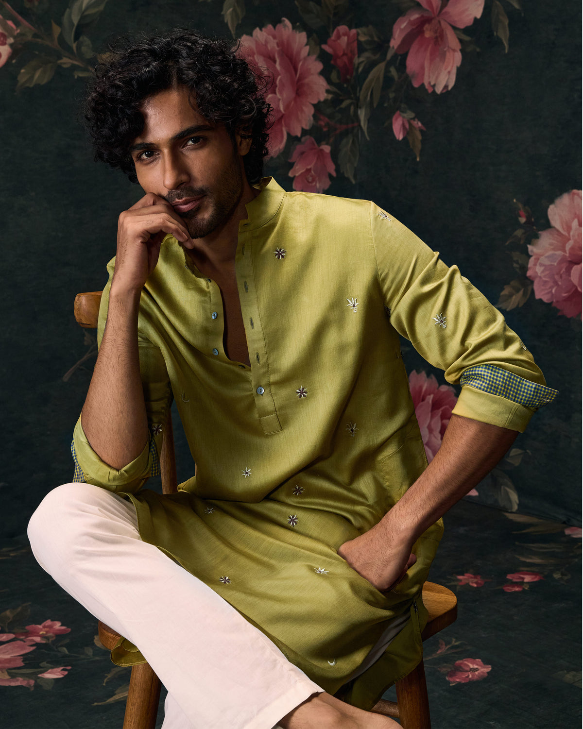 Person seated in an olive Rey kurta with small embroidered motifs.