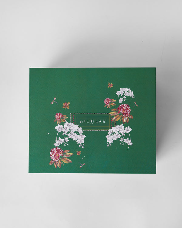 The closed green box with white and pink flowers