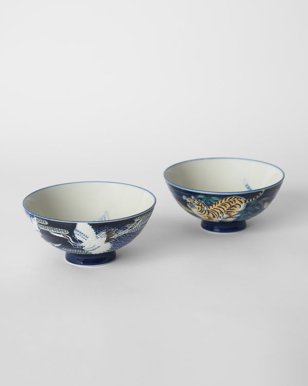 The bowls side by side, a white crane and an orange tiger on blue