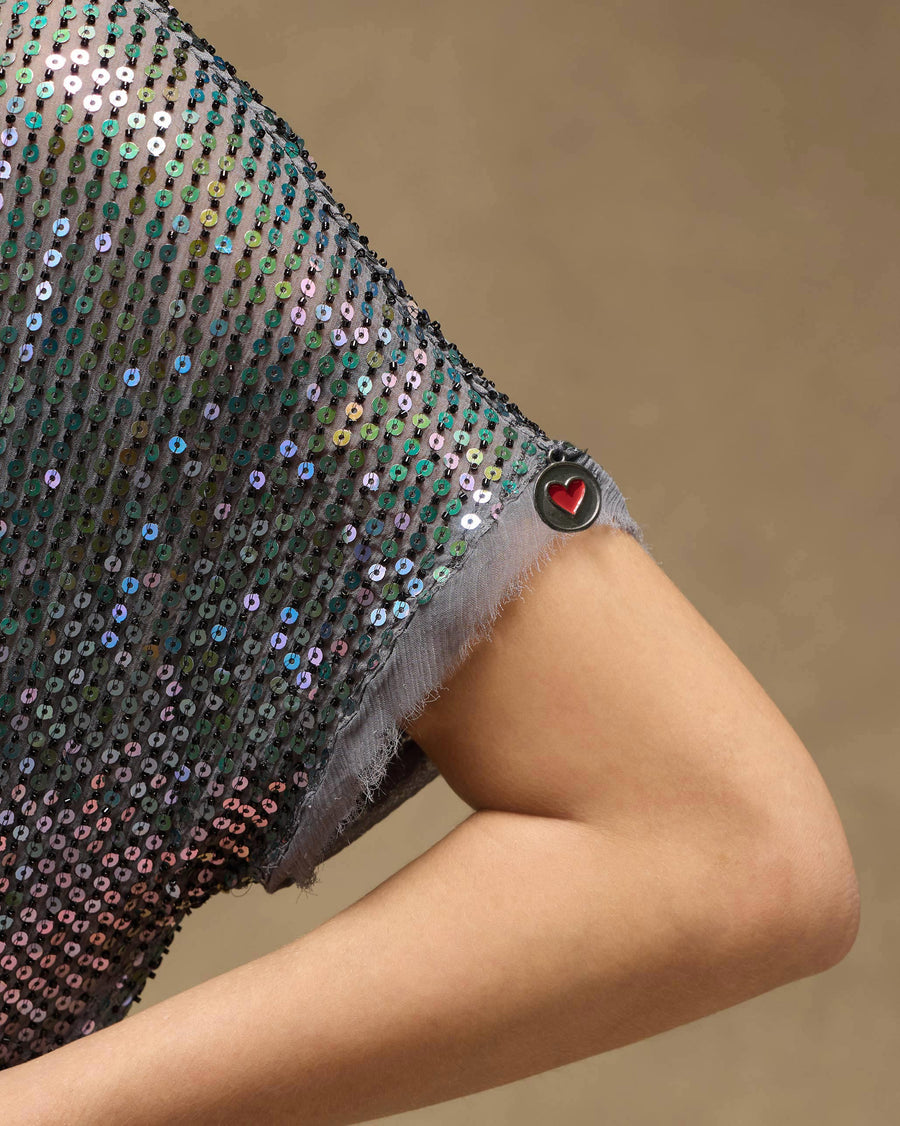 Close-up of the raw-edged sleeve of the Shimmer Dress, with a small red heart at the edge.