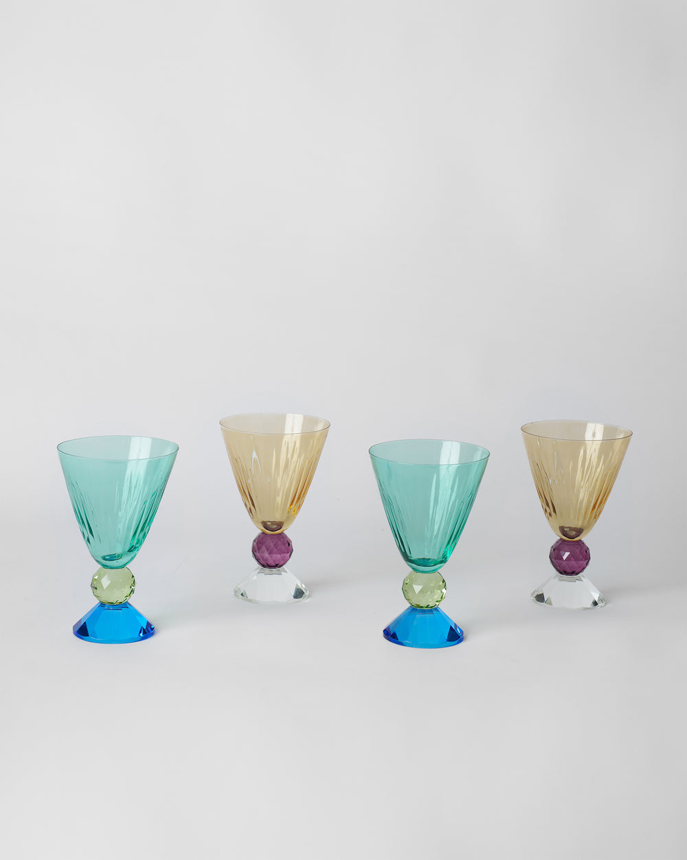 Vira Cocktail Glass, two teal and two amber, each on its crystal ball and foot