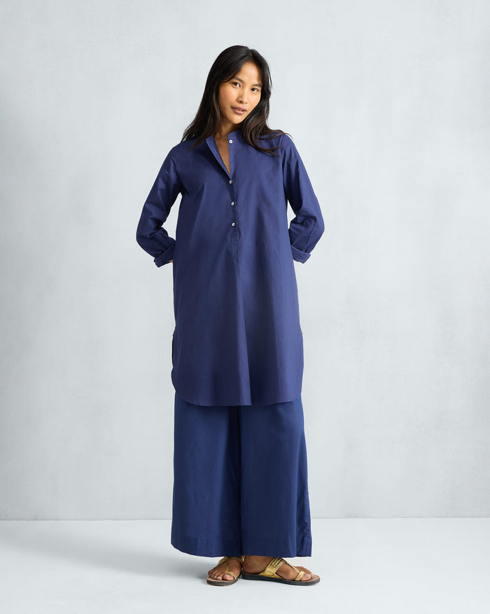 Person wearing an ink blue mid-length kurta set with matching pants.