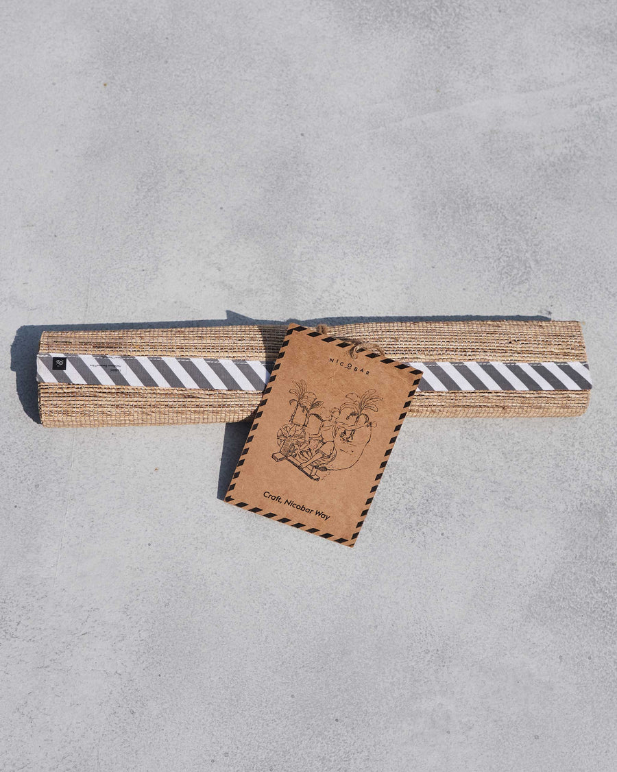The rolled runner with its striped band and craft tag.