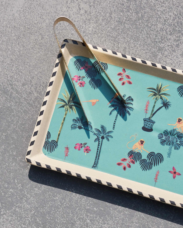 Close view of palms and birds on teal with the tongs