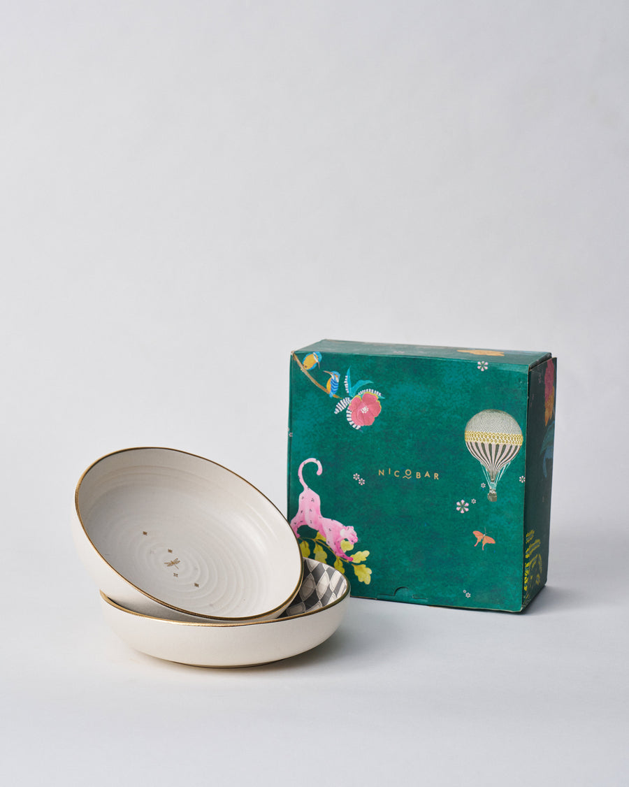 The Fez Shallow Bowls beside a teal Nicobar gift box.