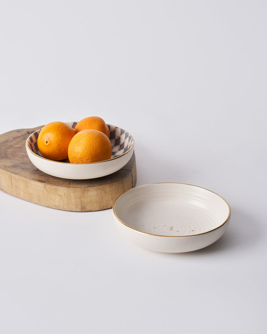 A Fez Shallow Bowl holding oranges.