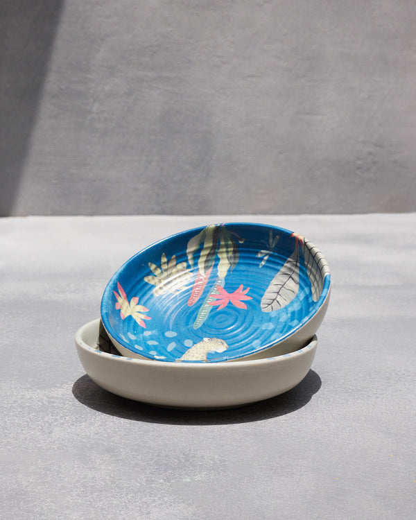 The blue bowl stacked on the cream one