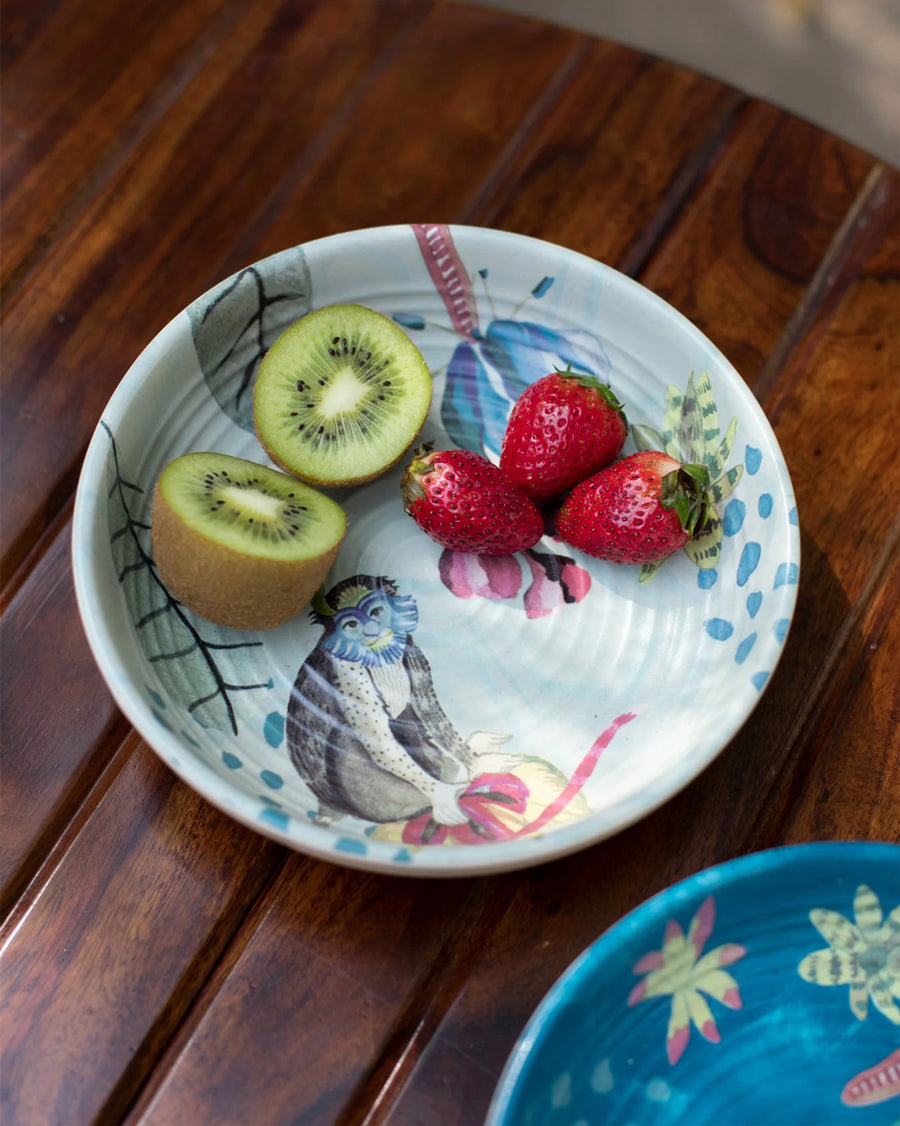 A Mahi bowl with kiwi and strawberries on a dark wooden table