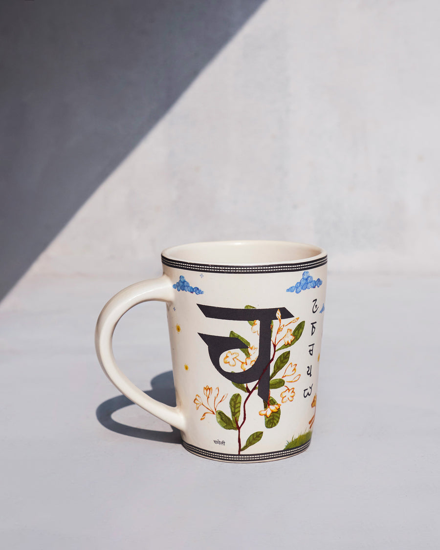 The Chameli Mug side-on, with the letter च and jasmine.