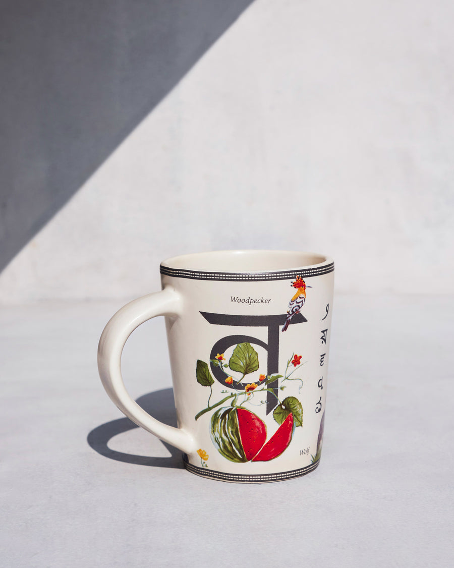 The Waterlily Mug side-on, with the letter व.