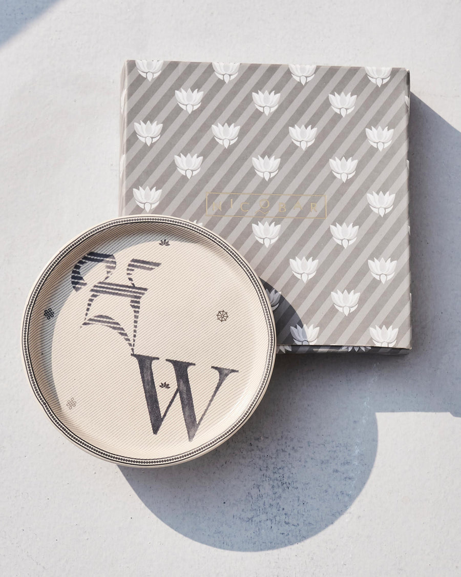 The Akshar Coaster beside its striped gift box.