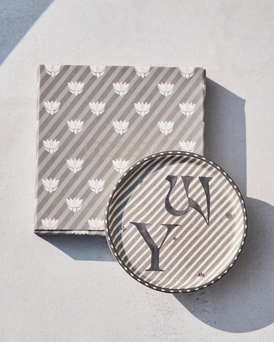 The Akshar Coaster beside its striped gift box.
