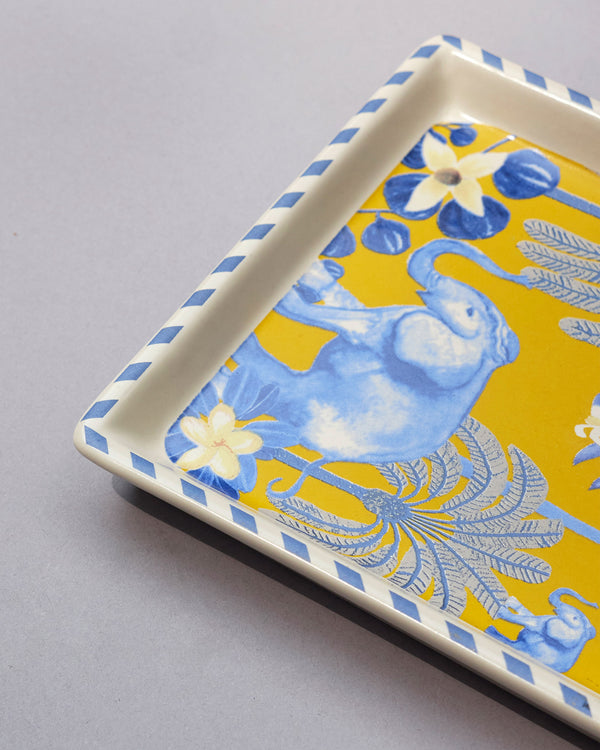 Close view of a blue elephant and palms on yellow
