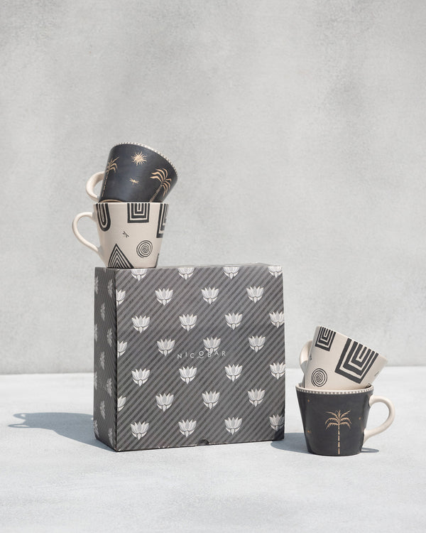 Mugs on and beside a grey patterned gift box