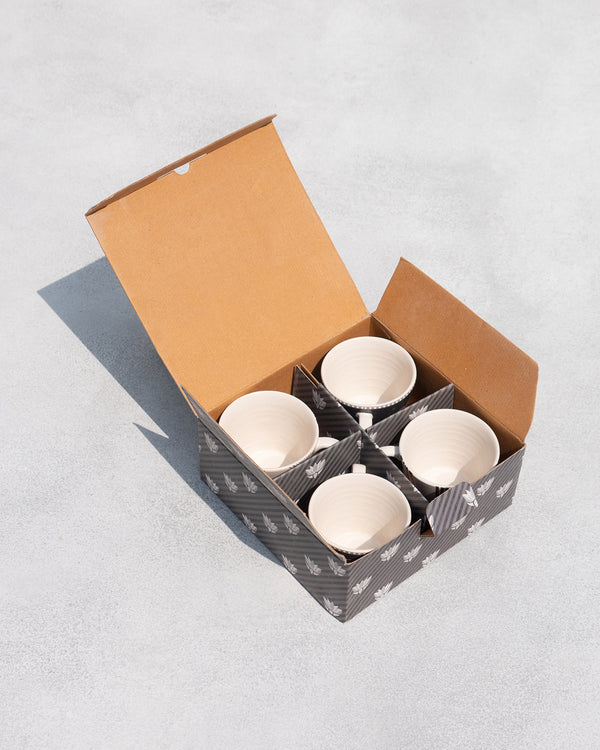 The open box from above, four mugs in their slots