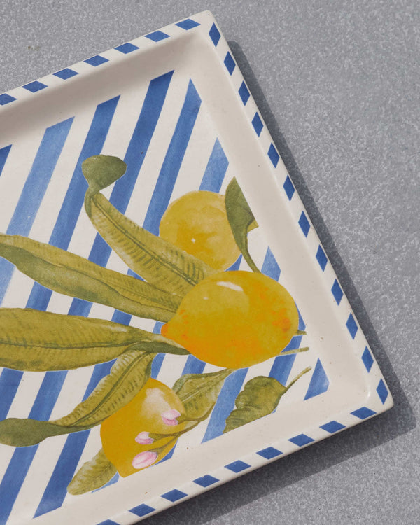 Close view of lemons and leaves on blue stripes