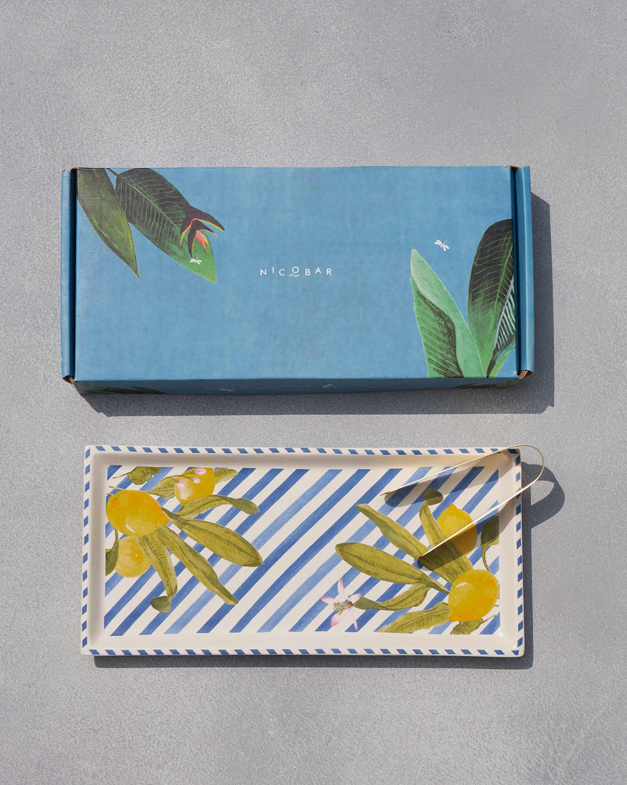 The tray and tongs below a pale blue leaf-print gift box