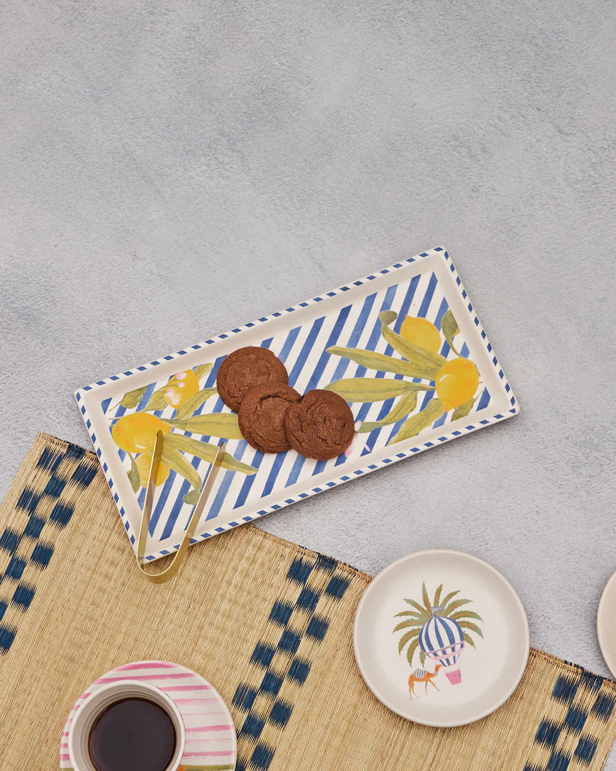 The Asfar tray with chocolate cookies on a woven mat beside coffee