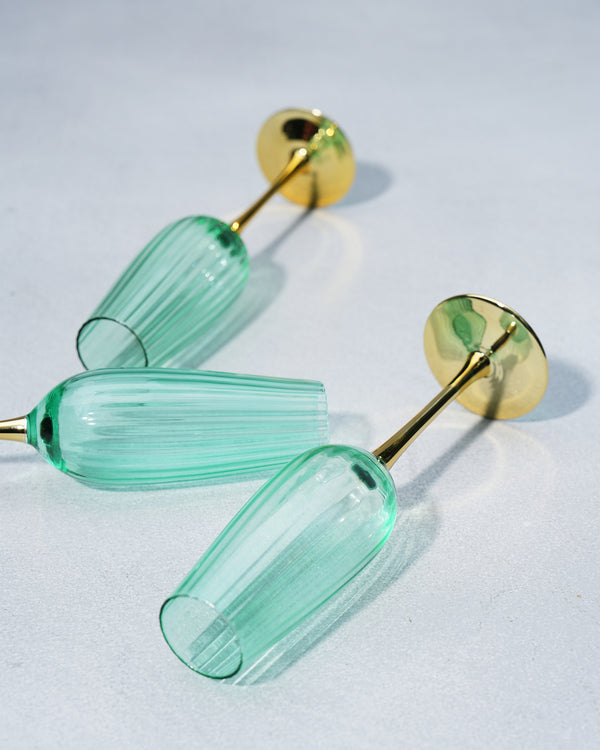 Flutes lying on their sides, the gold stems and bases in view