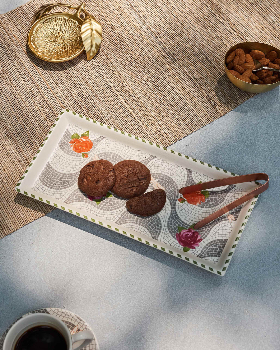 The Mosaic Bloom tray with chocolate cookies and copper tongs on a table