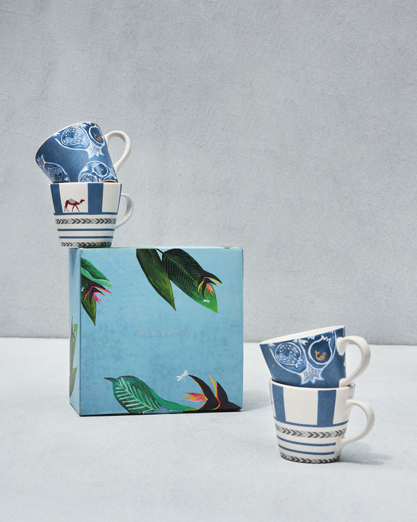 Mugs on and beside a blue gift box with leaves and birds