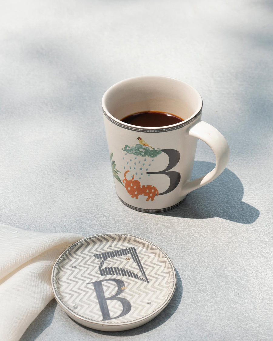 The B mug of coffee beside its matching B coaster
