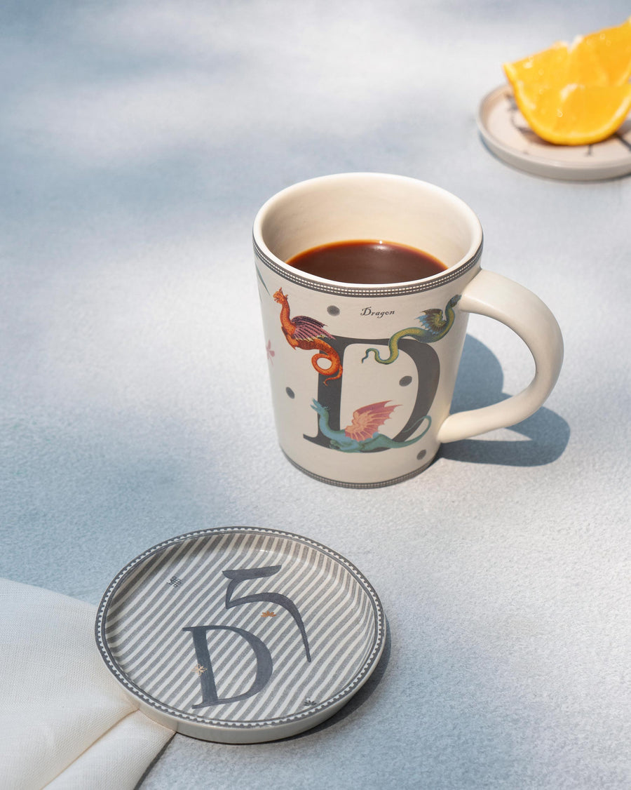 The D mug of coffee beside its matching D coaster