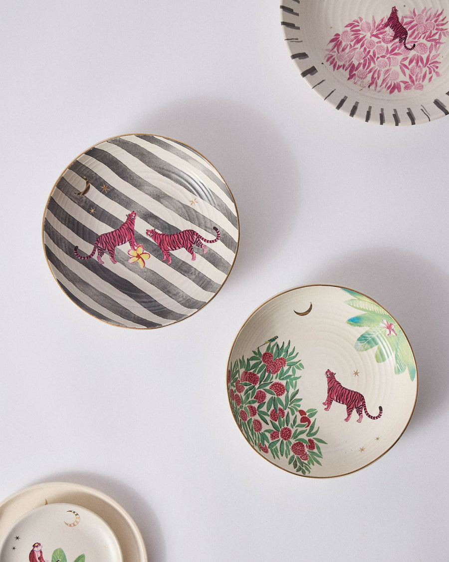 Two Ceylon Trail bowls from above, pink tigers on stripes and on red blossoms