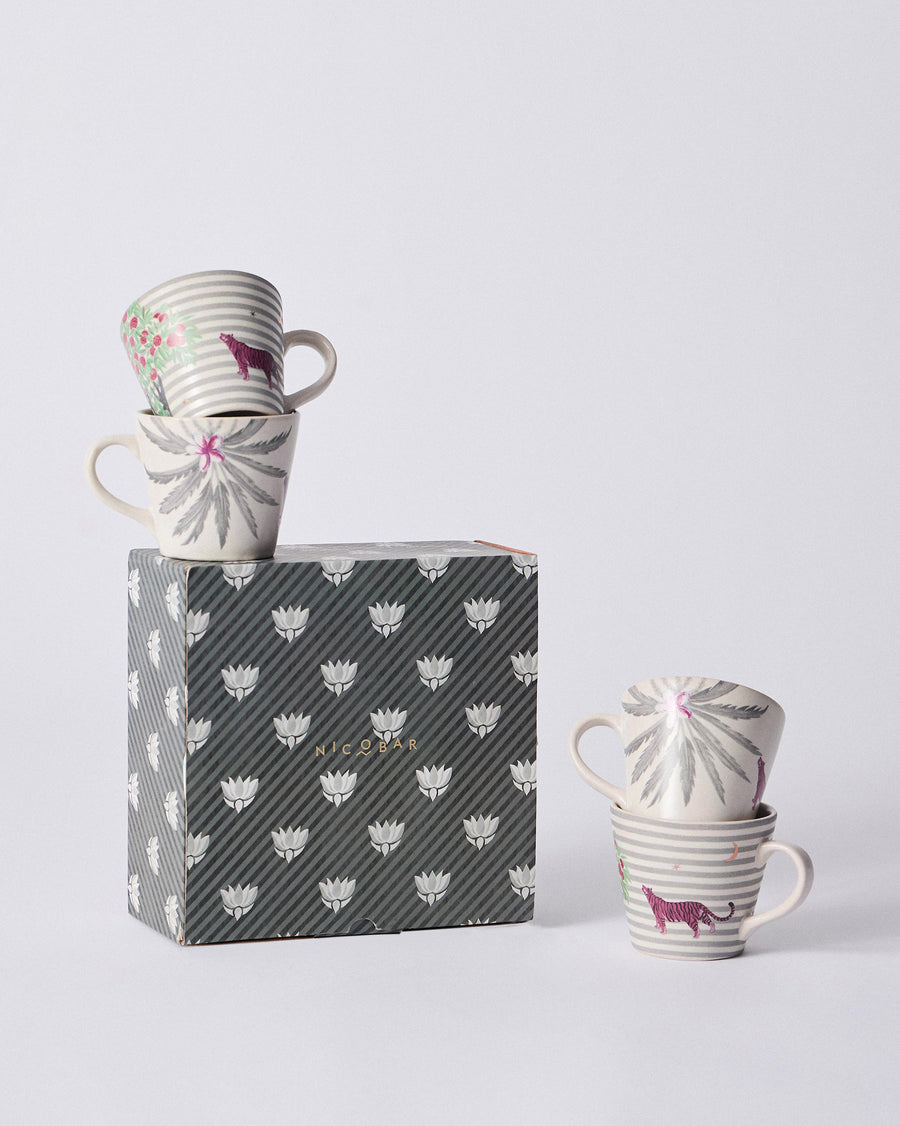 The mugs on and beside a grey patterned gift box