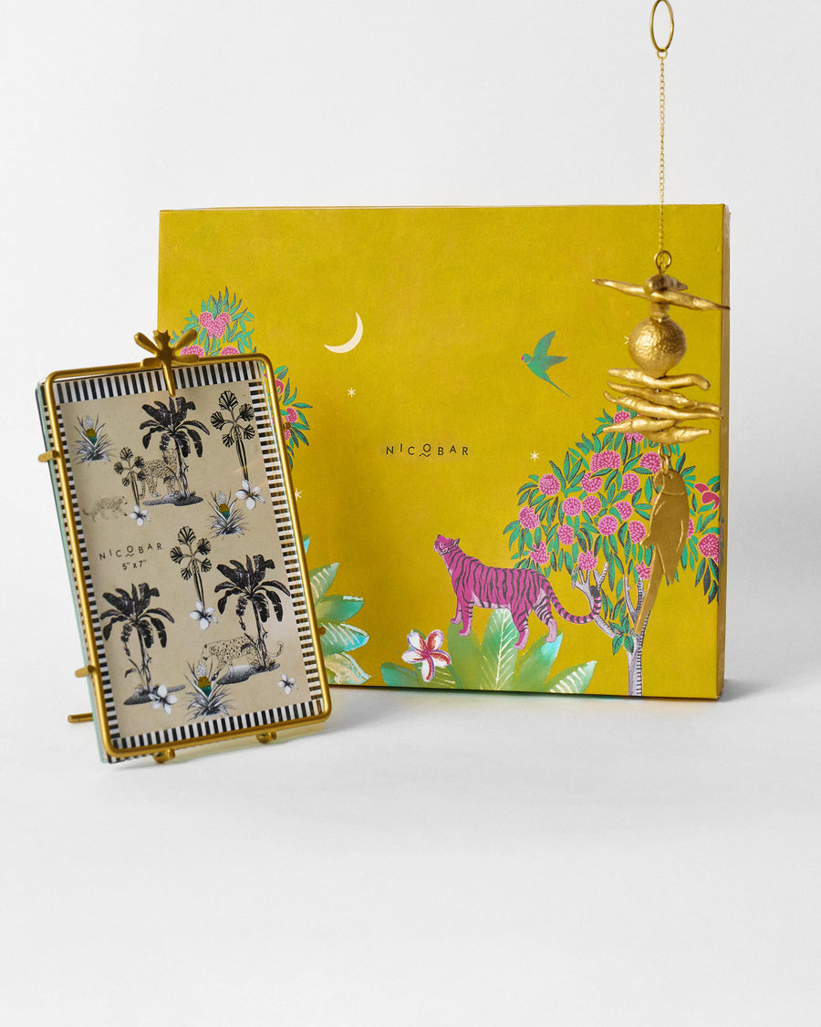 The frame and charm in front of the mustard yellow jungle-print box