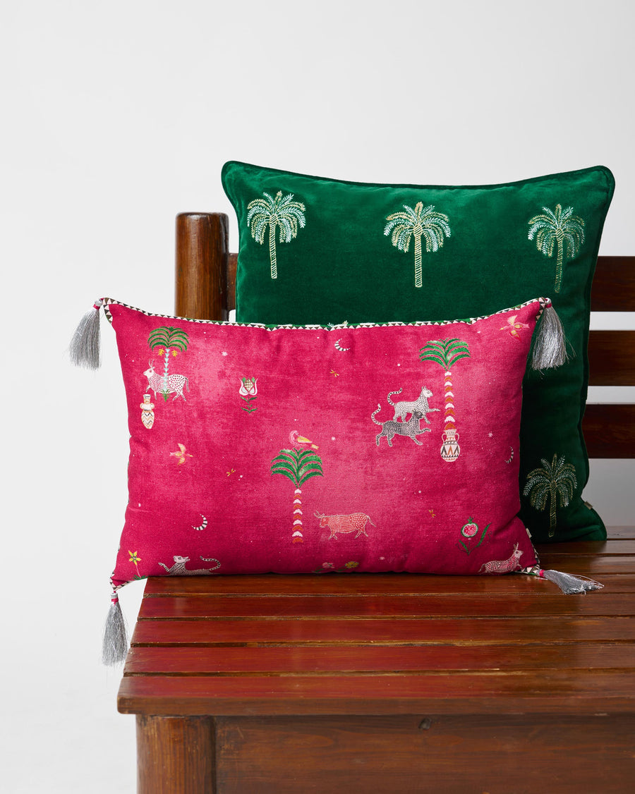 The magenta Harappa cushion on a wooden bench in front of green cushions