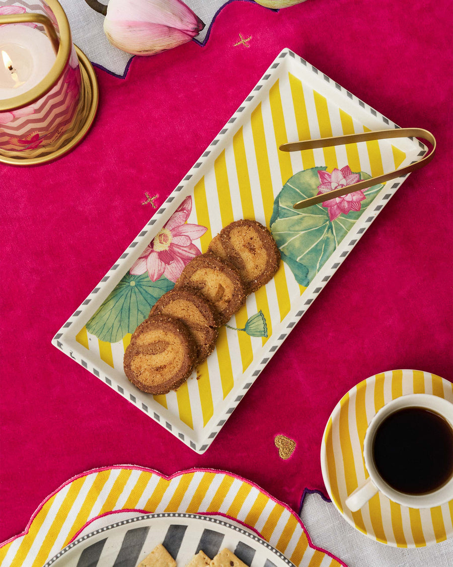 The yellow Lotus Garden tray with spiral cookies on a pink table