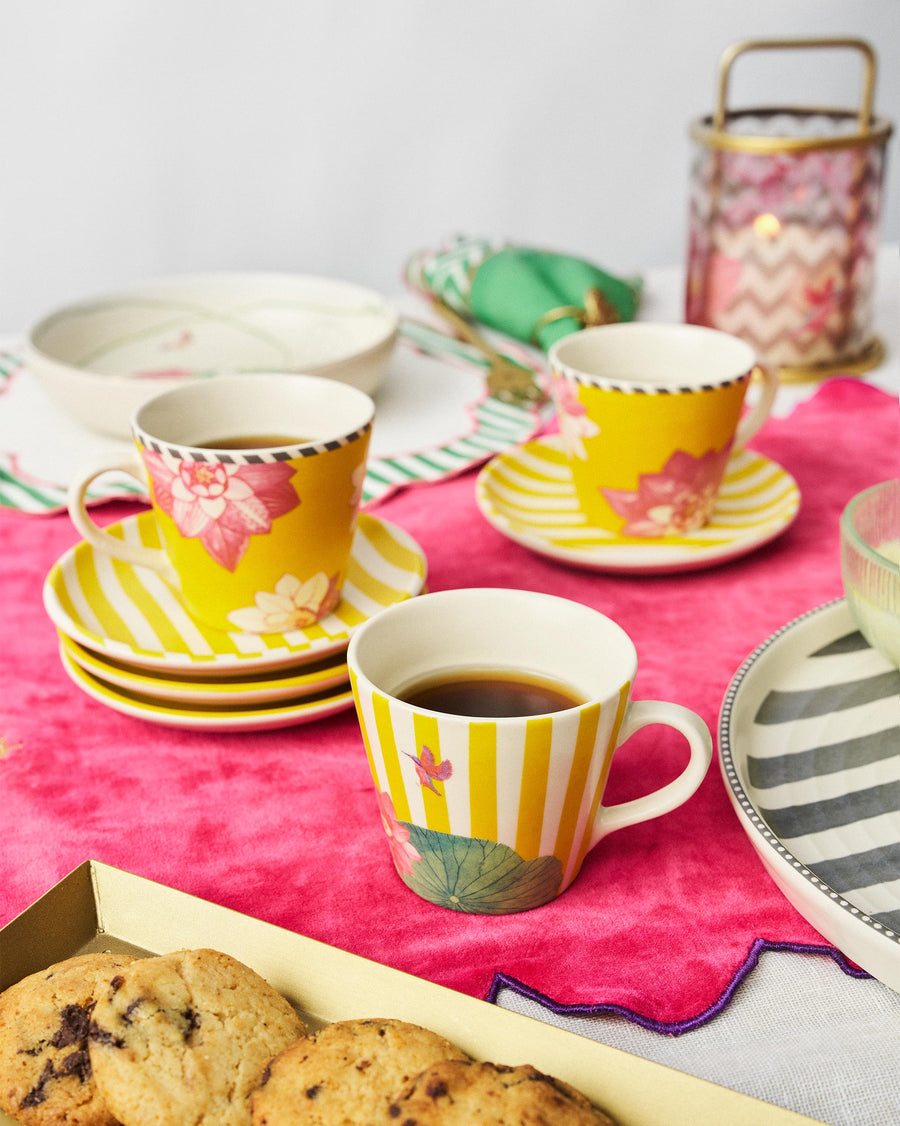Lotus Garden mugs of coffee on a pink cloth beside cookies
